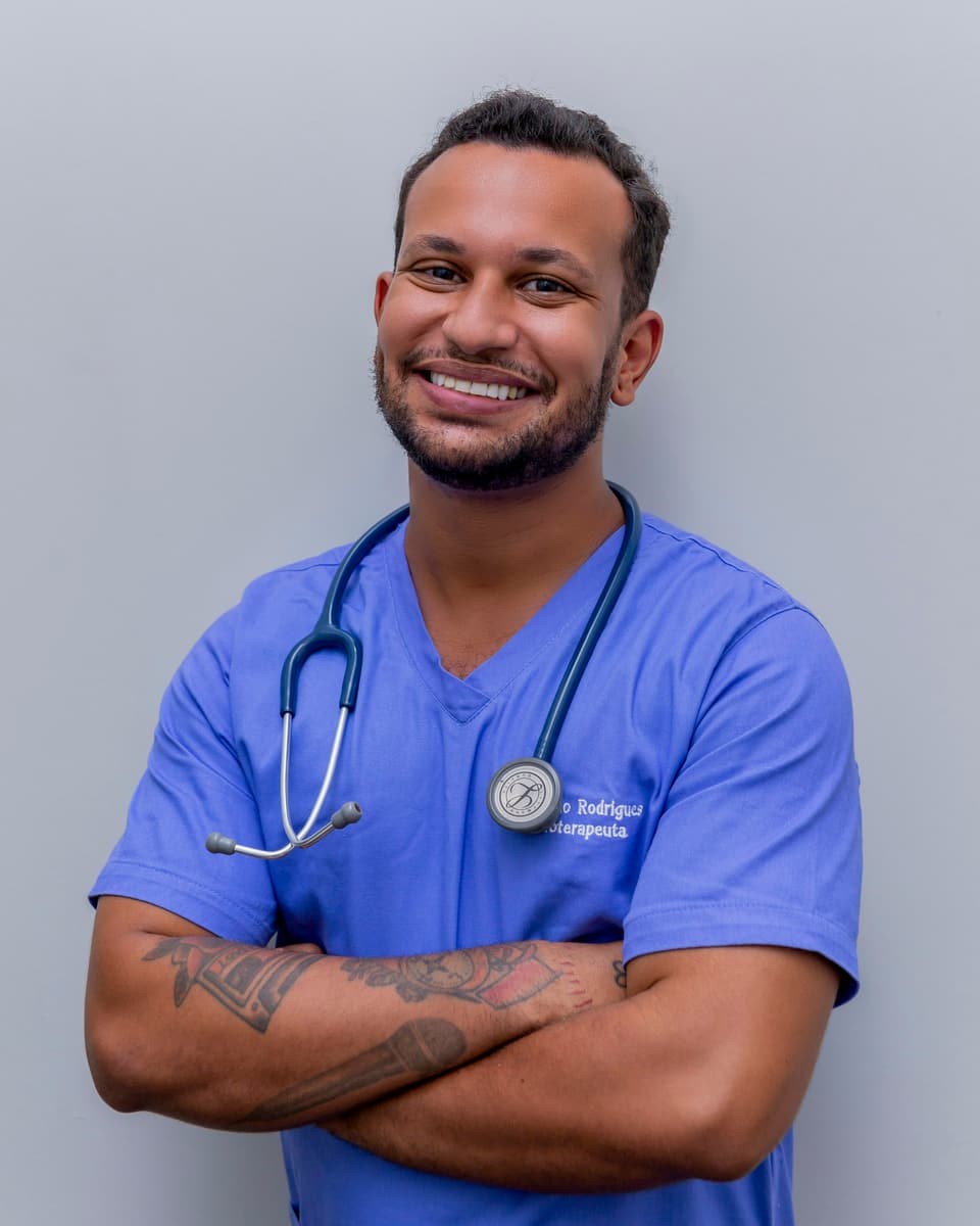 Dentista sorrindo com uniforme azul e estetoscópio no pescoço