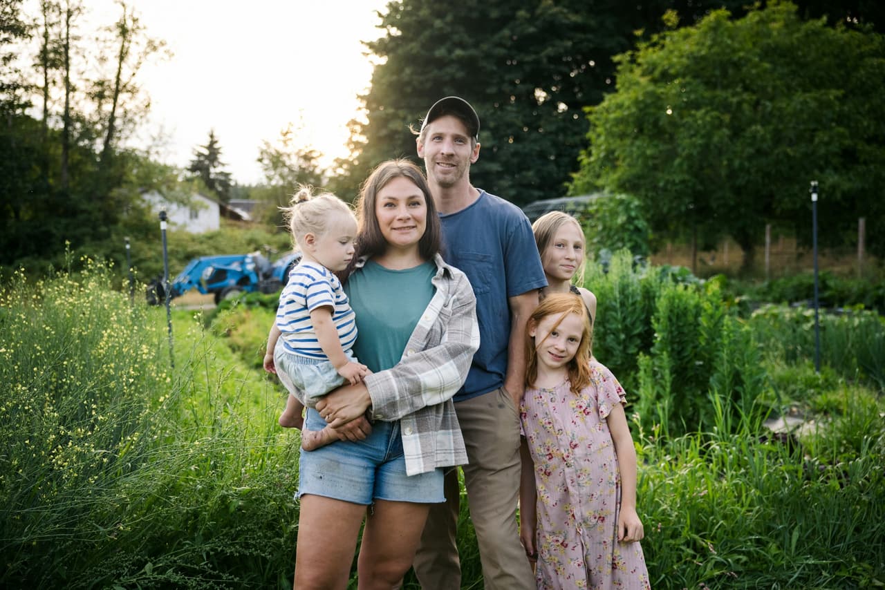 Família com crianças posando em um jardim ao fim da tarde